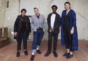 A group of 4 people standing together to discuss poetry