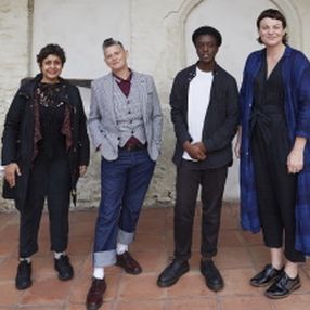 A group of 4 people standing together to discuss poetry