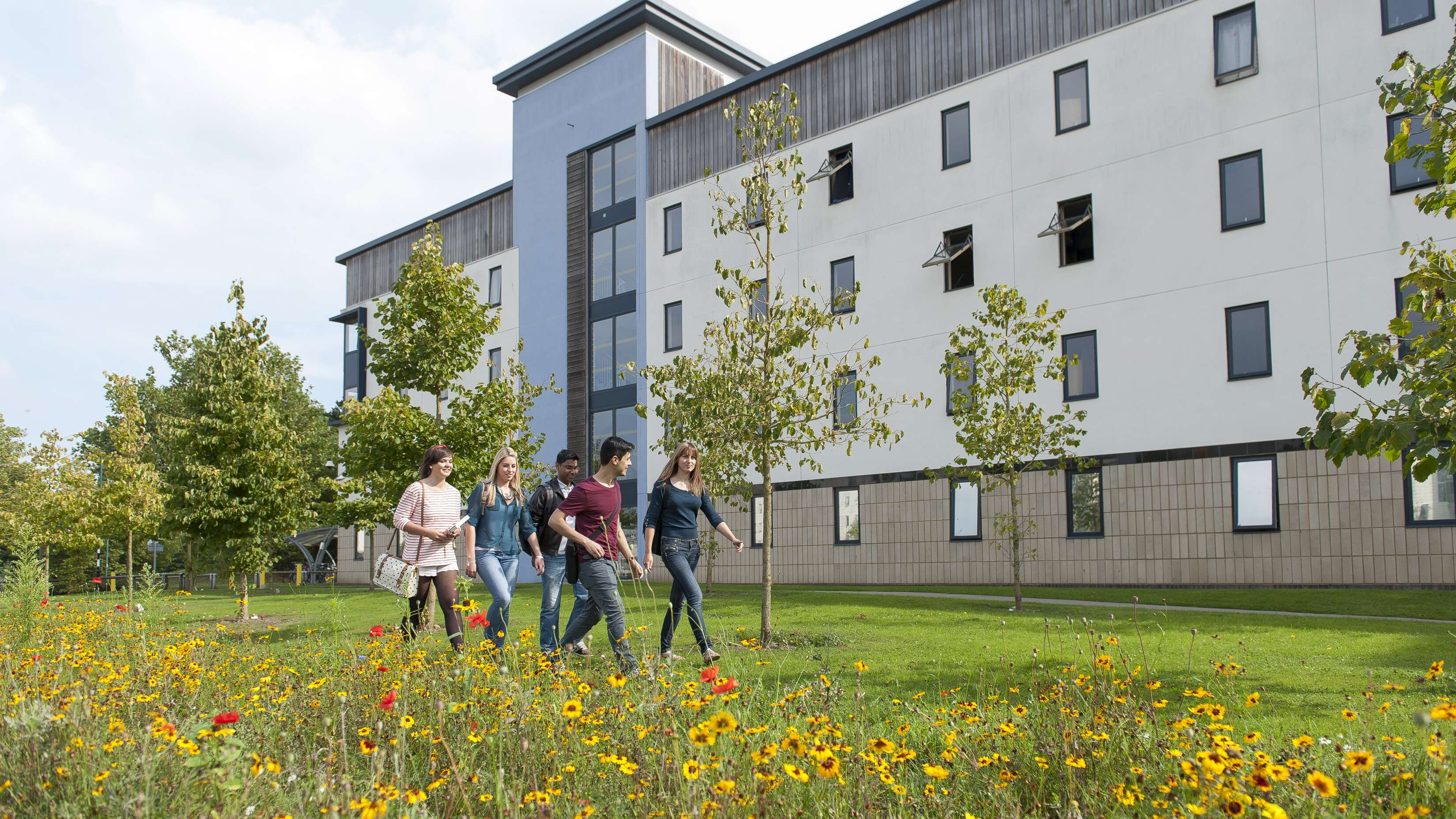 Student walking past Paston House on Campus