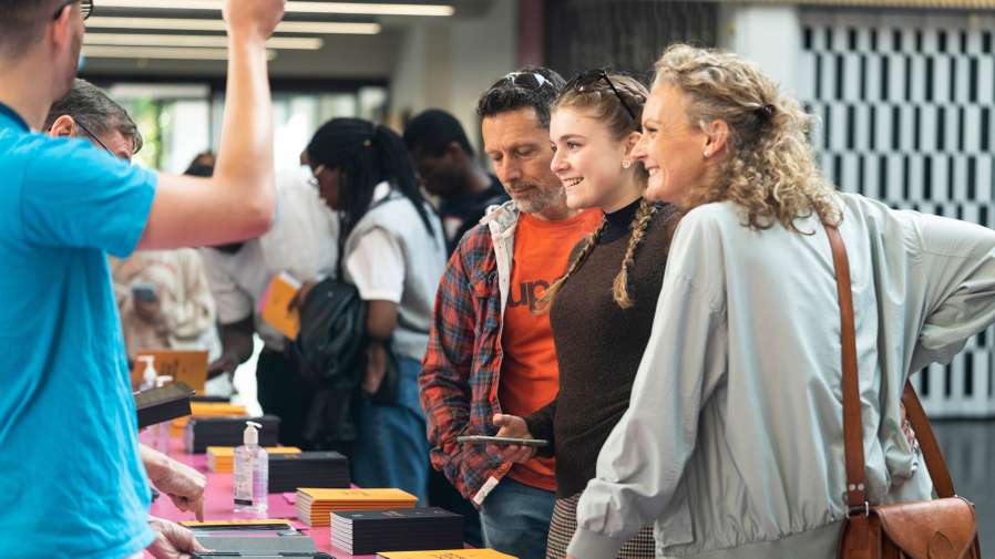 Young person and parents talking to UEA staff