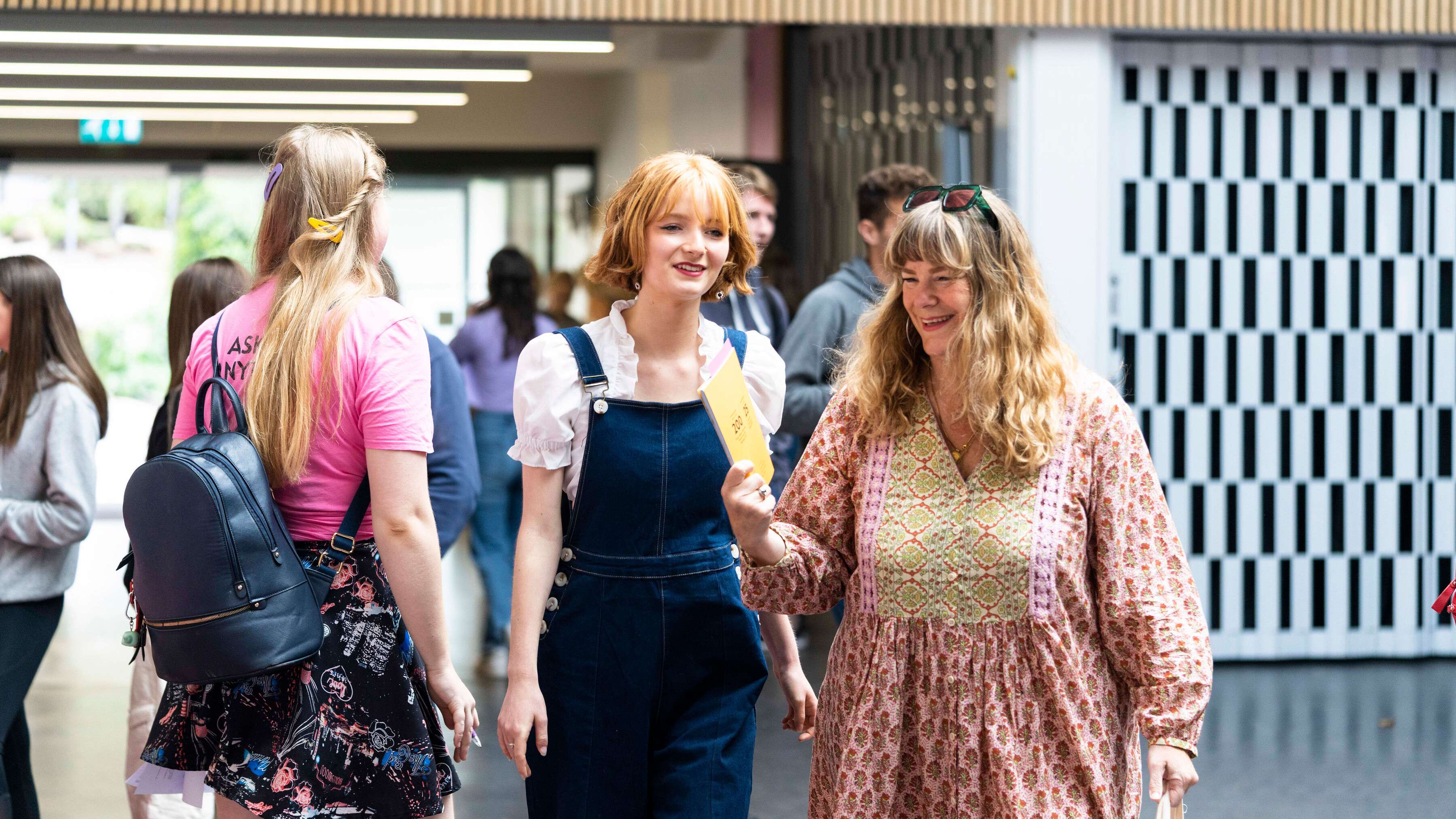two person smiling holding a brochure