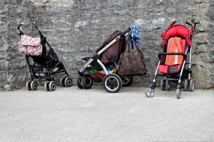 Three baby strollers against a wall
