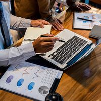 people working on laptops and spreadsheets 