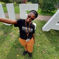 Student taking picture with UEA sign
