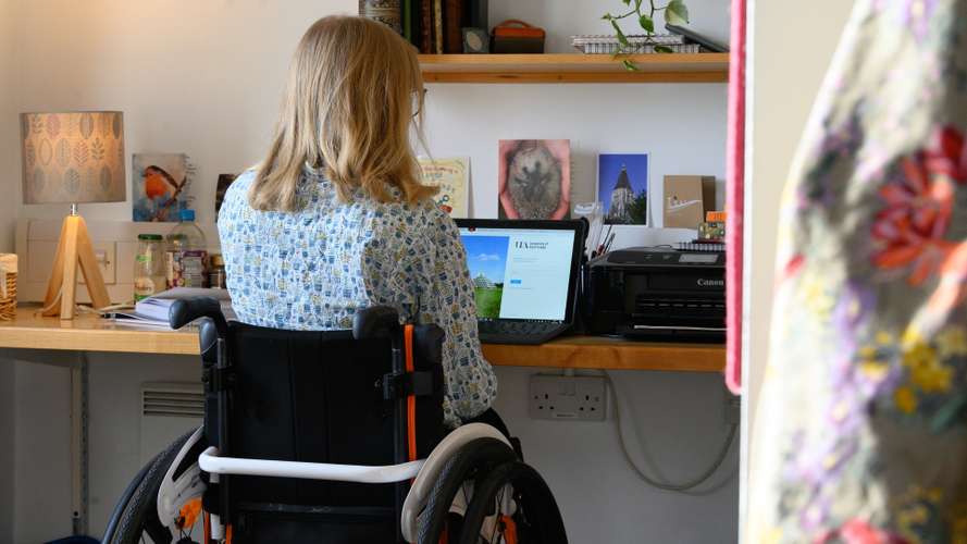 A UEA student is pictured at her desk using a laptop in a specially adapted room for wheelchair users at the University of East Anglia.