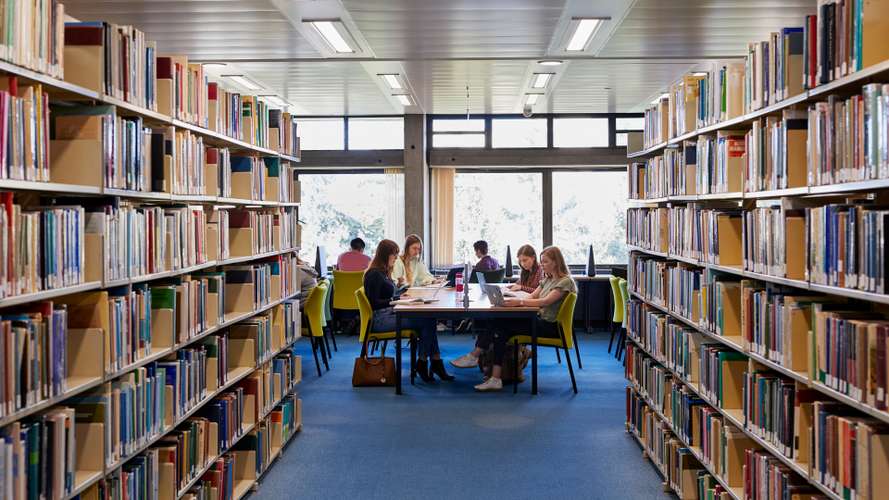 WeLaunch students and bookshelves in the library
