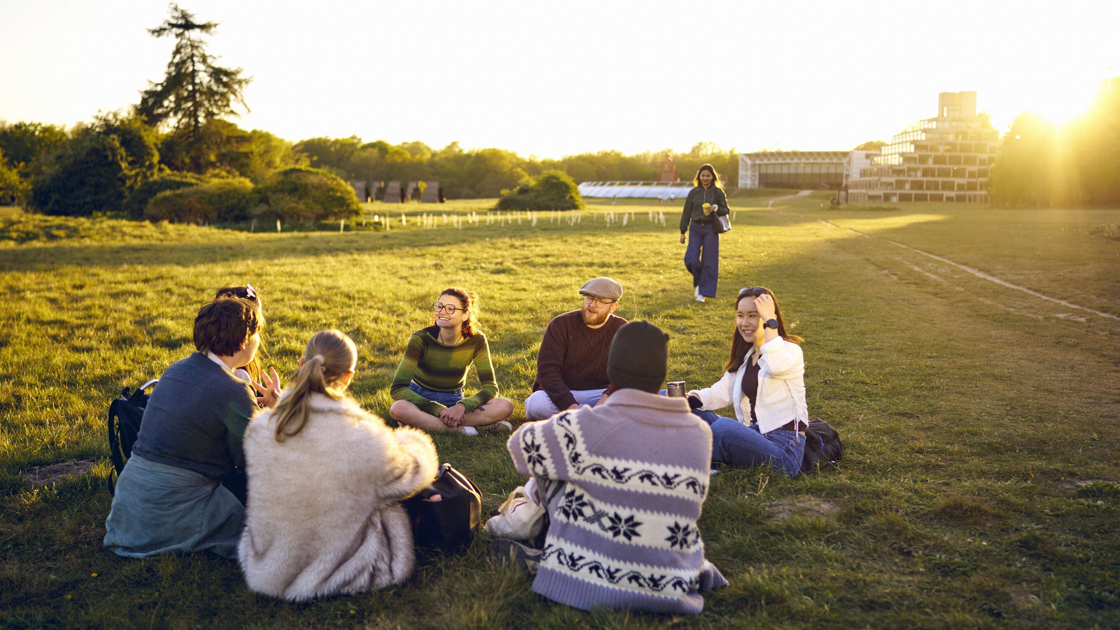 A group of students sitting on the grass on campus