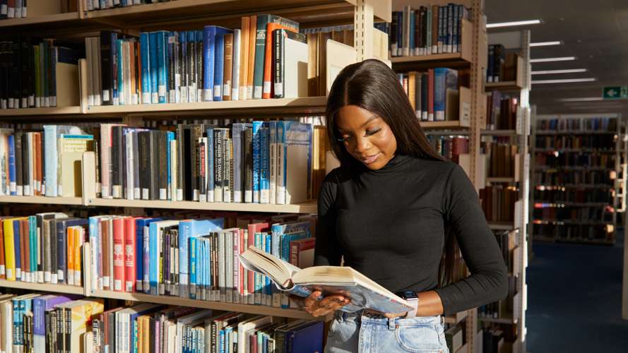 Student browsing bookshelves in the Library