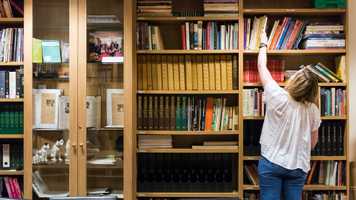 Student looking through bookshelves
