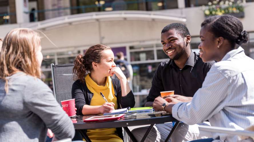 Group of UEA students studying and talking on campus in The Square