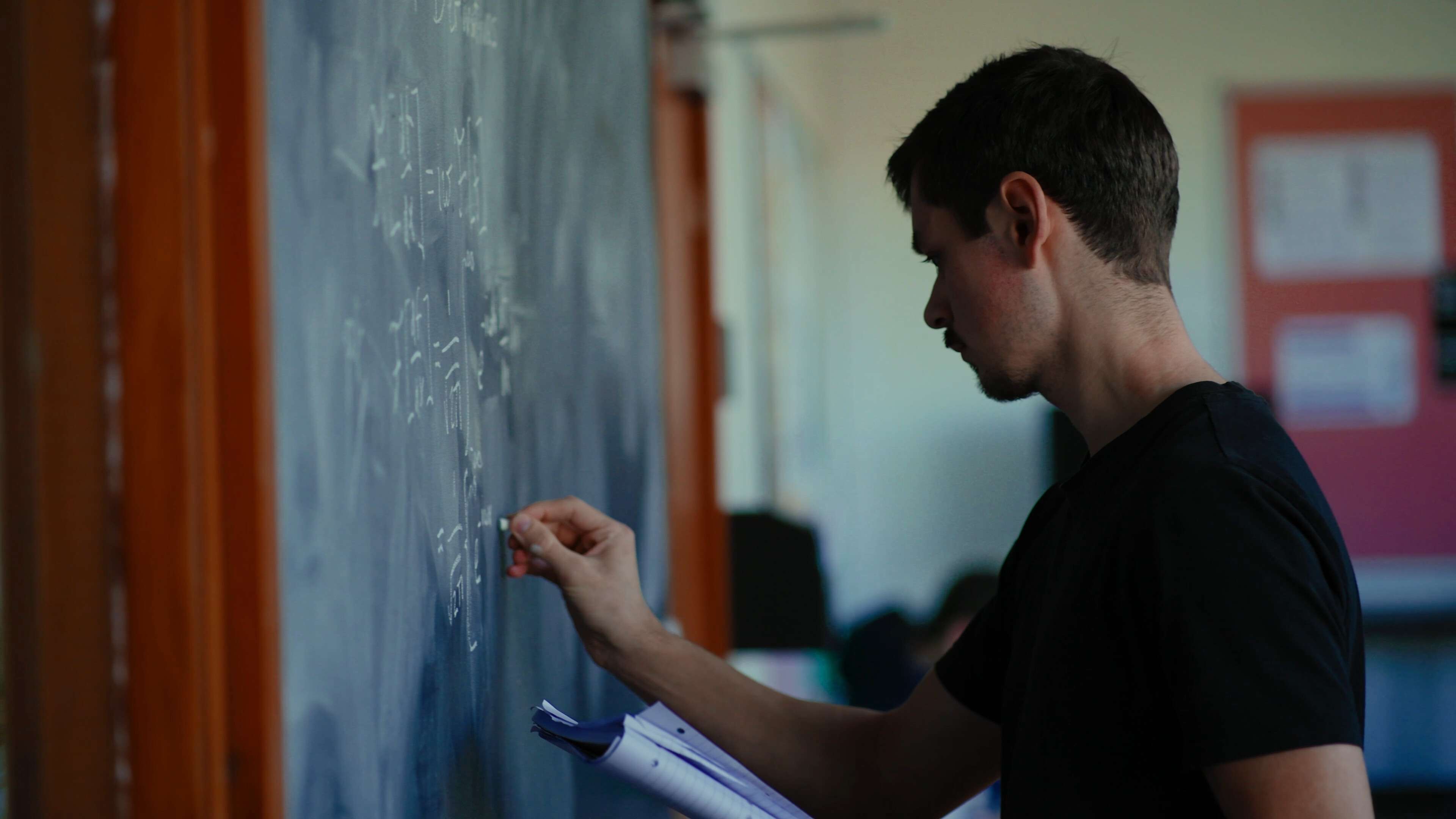 Mathematics student writing on a chalkboard