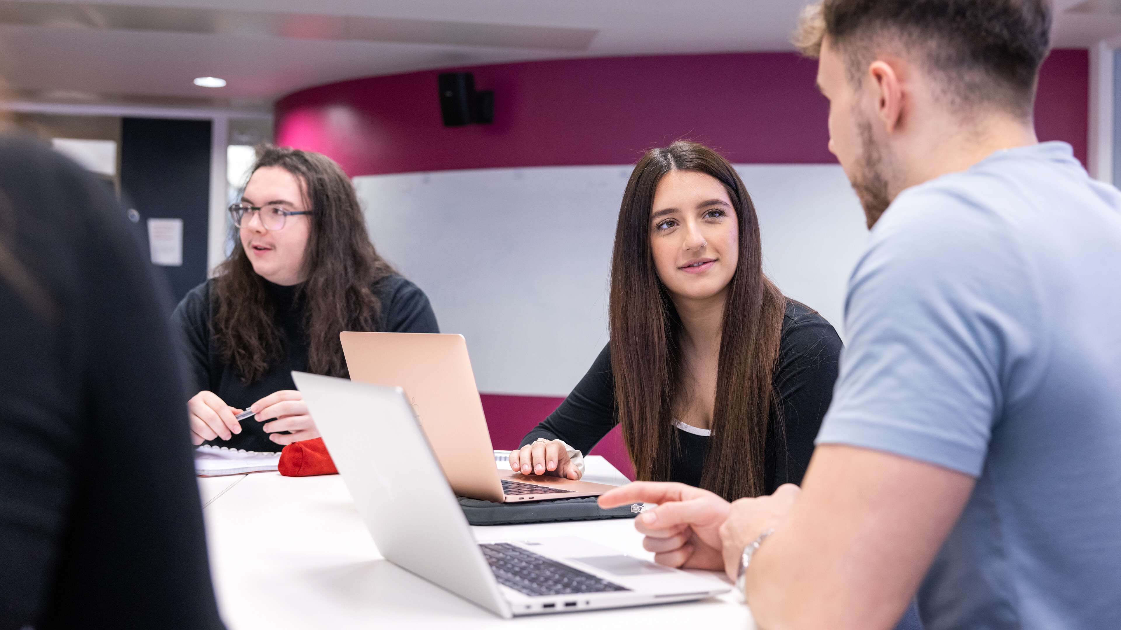 Students with laptops studying together