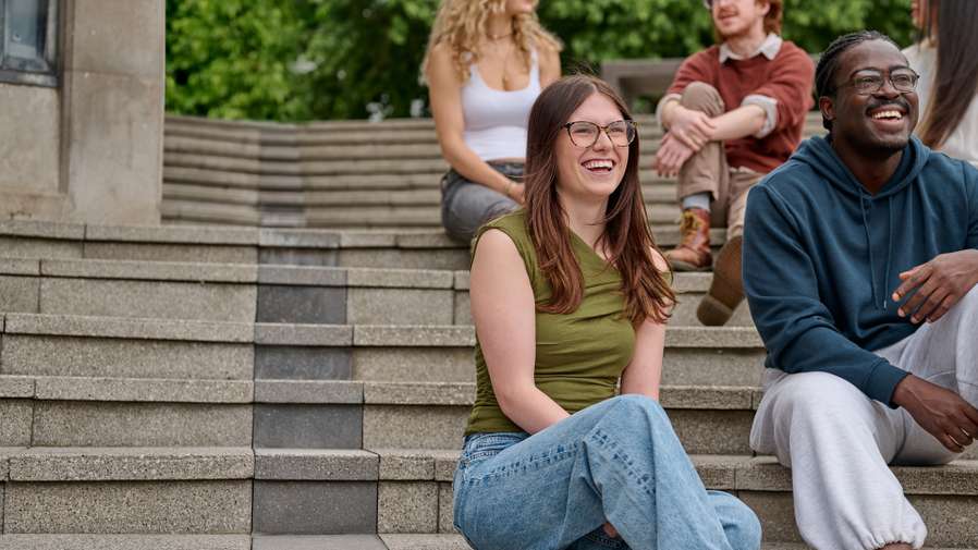 Five students sitting on steps.
