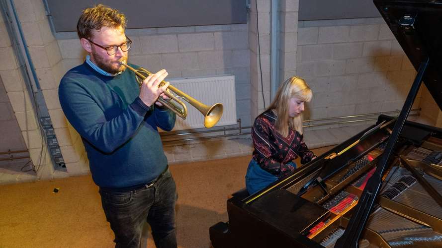 Students playing the trumpet and piano