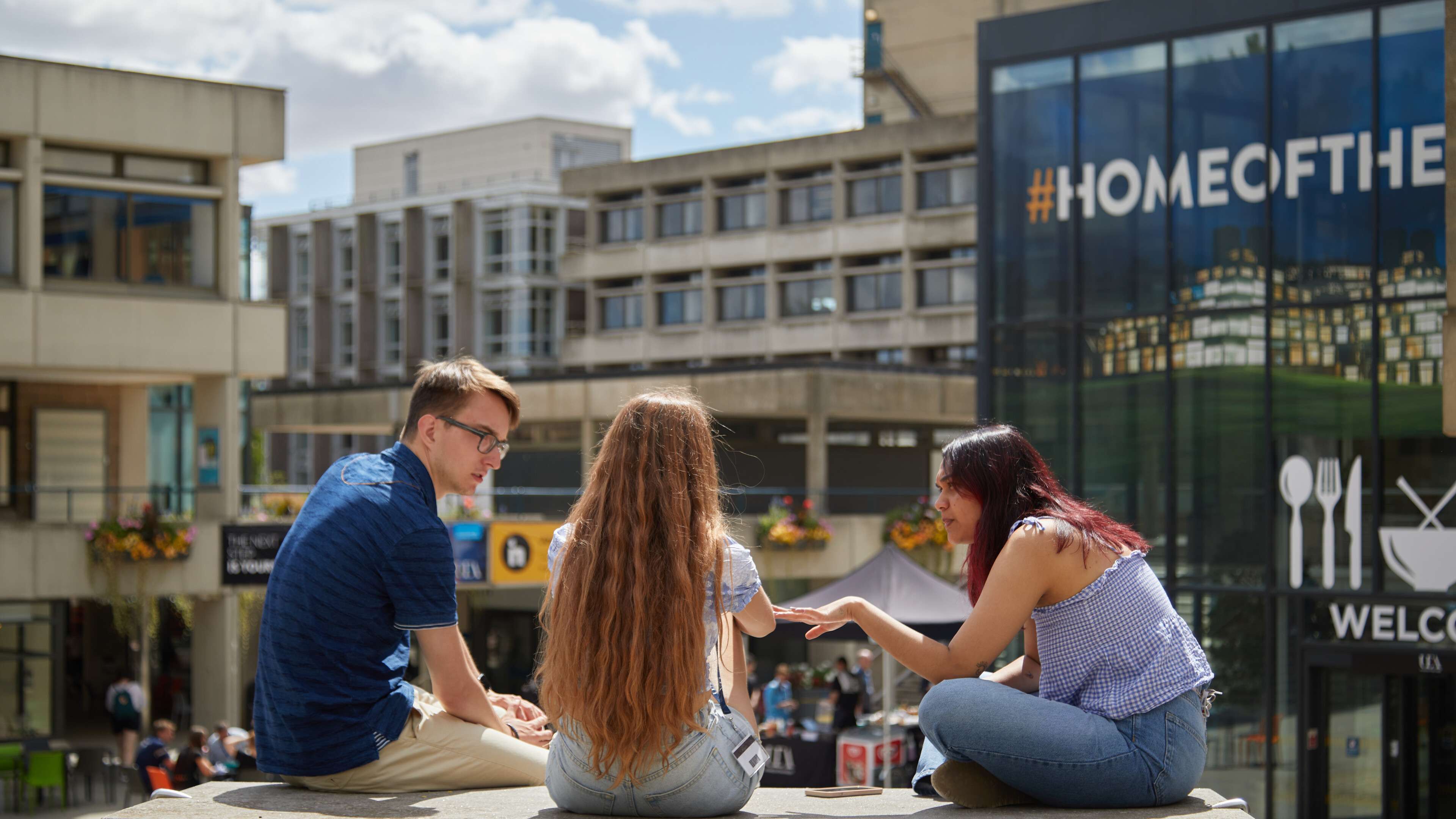 A group of students talking in the Square on the UEA campus