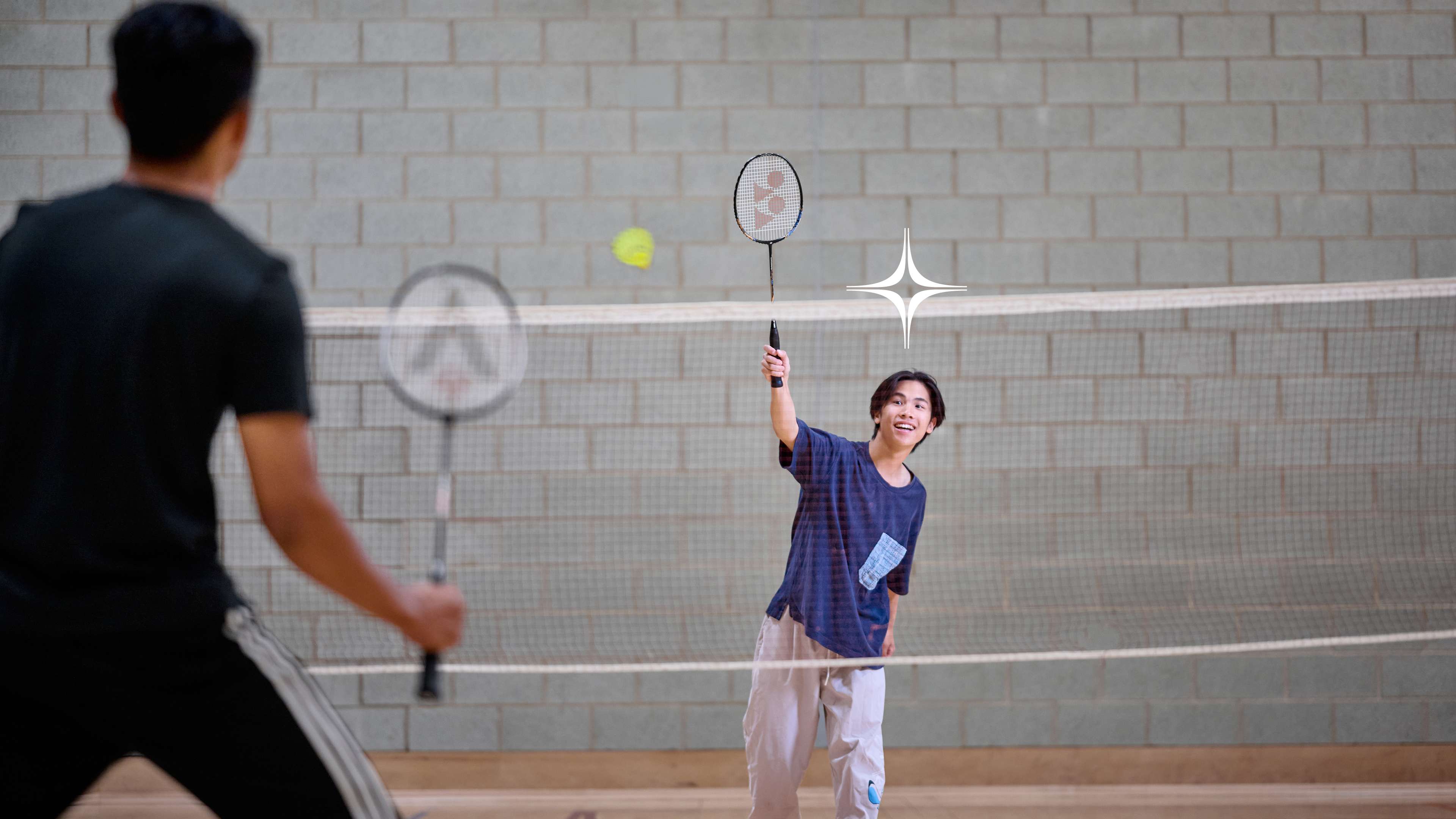 Two students play badminton.