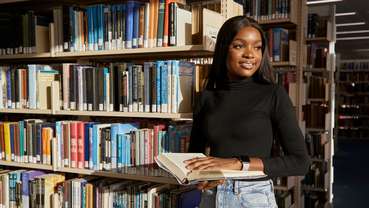 Student browsing bookshelves in the Library