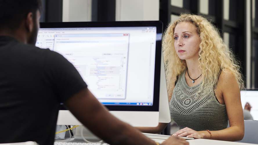 Mature students working on computers in media suite