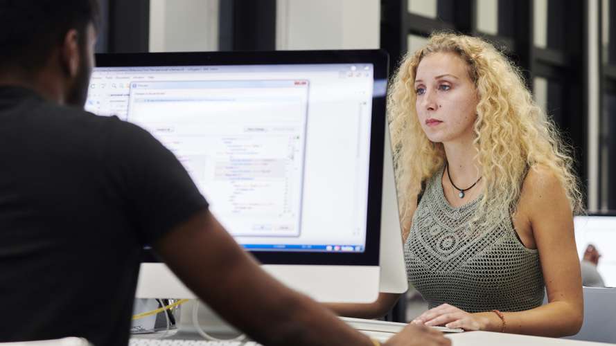 Mature students working on computers in media suite