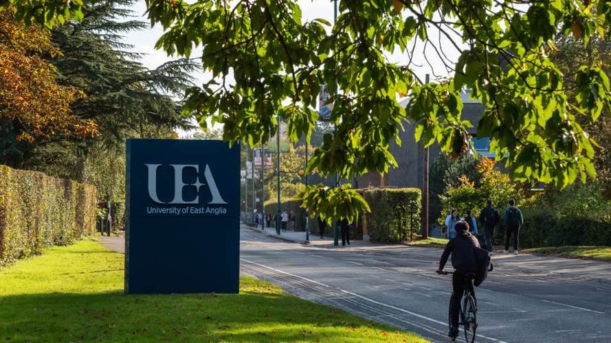 Cyclist biking down UEA main entrance