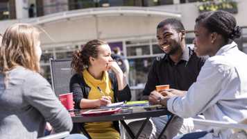 Students sitting outside at a table on campus