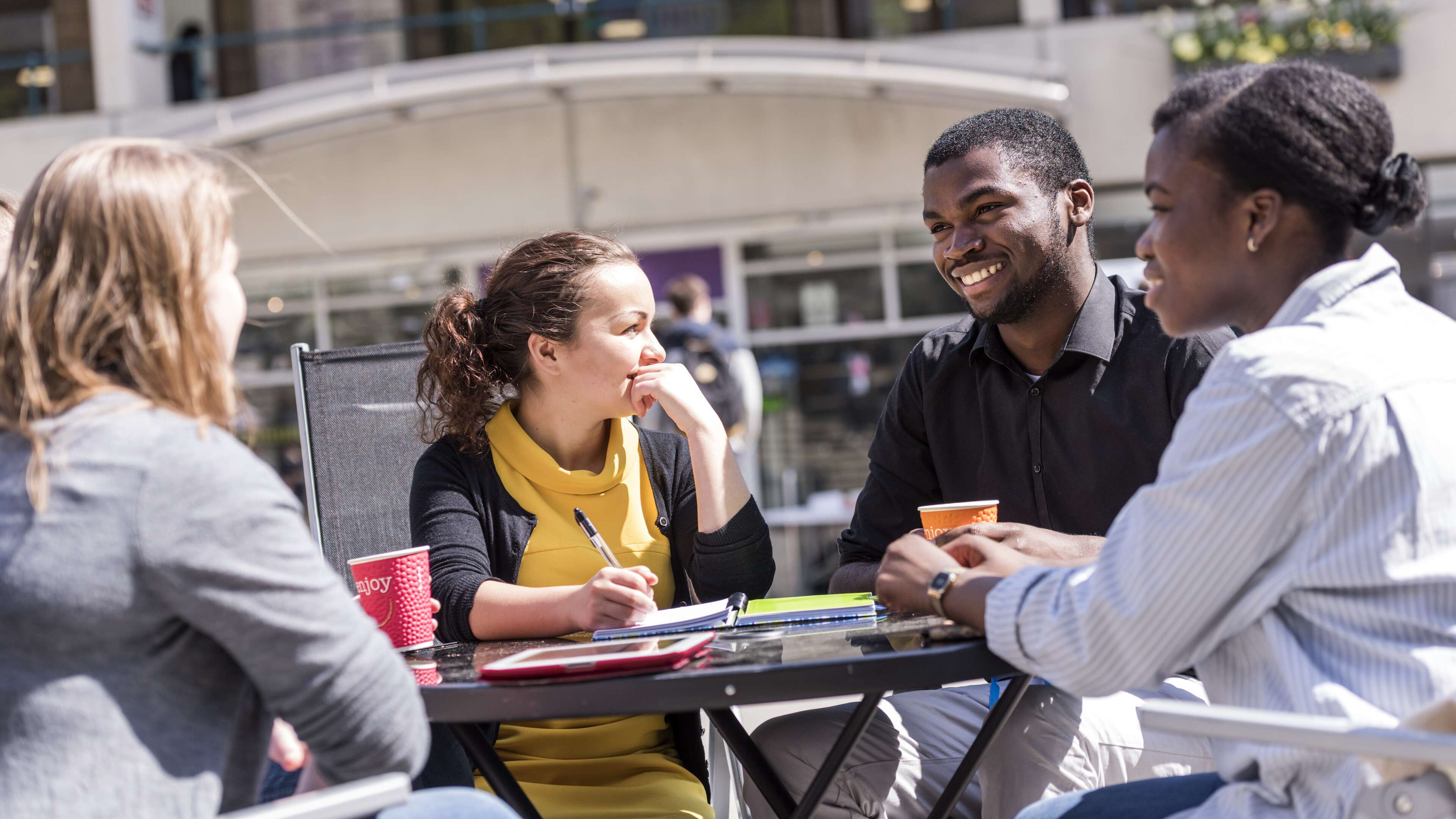 Students sitting outside at a table on campus