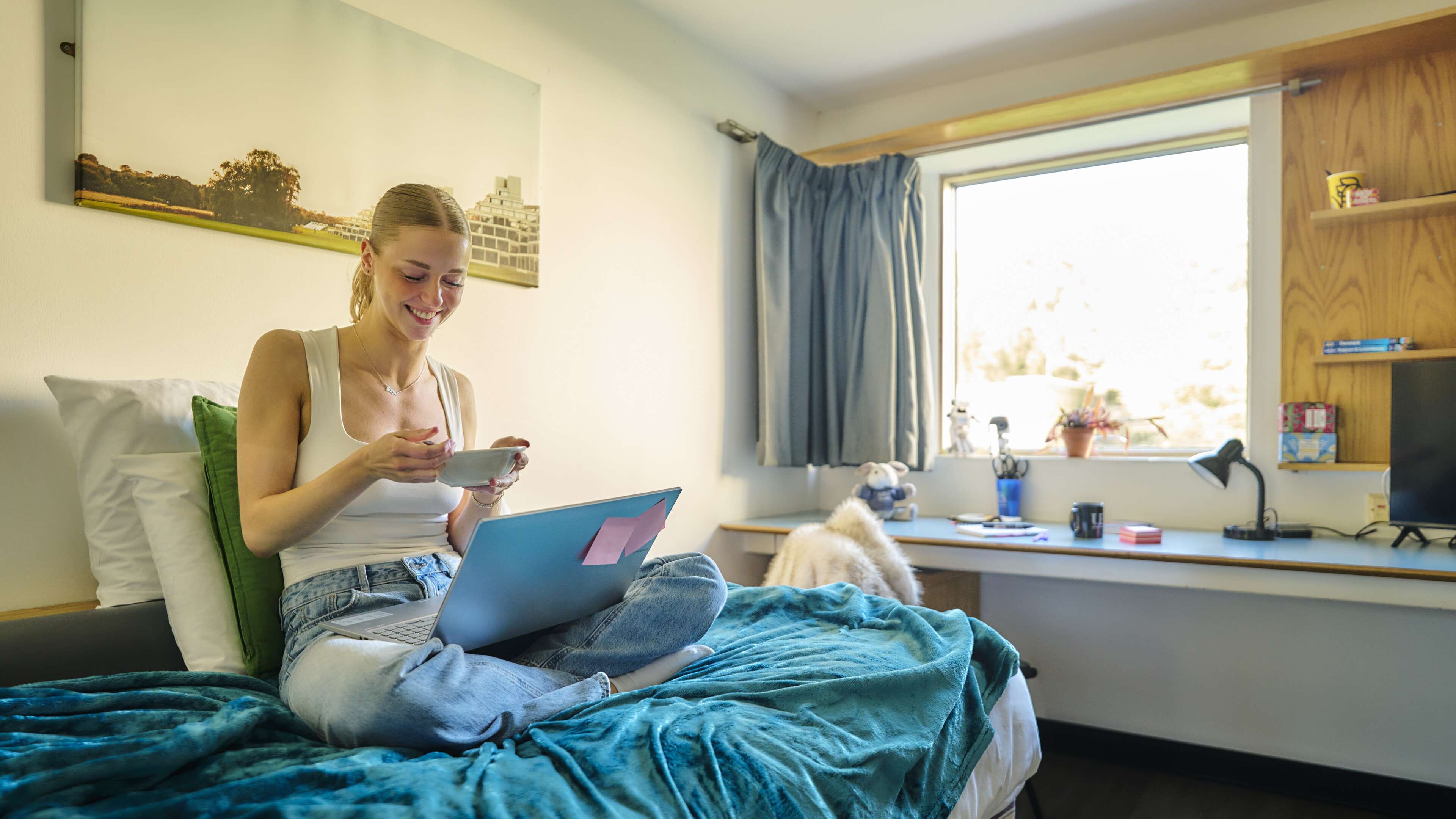 A student sitting in a bedroom on campus