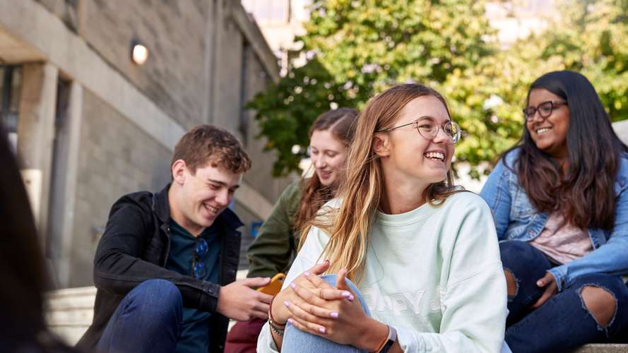 Students sitting on steps in the square