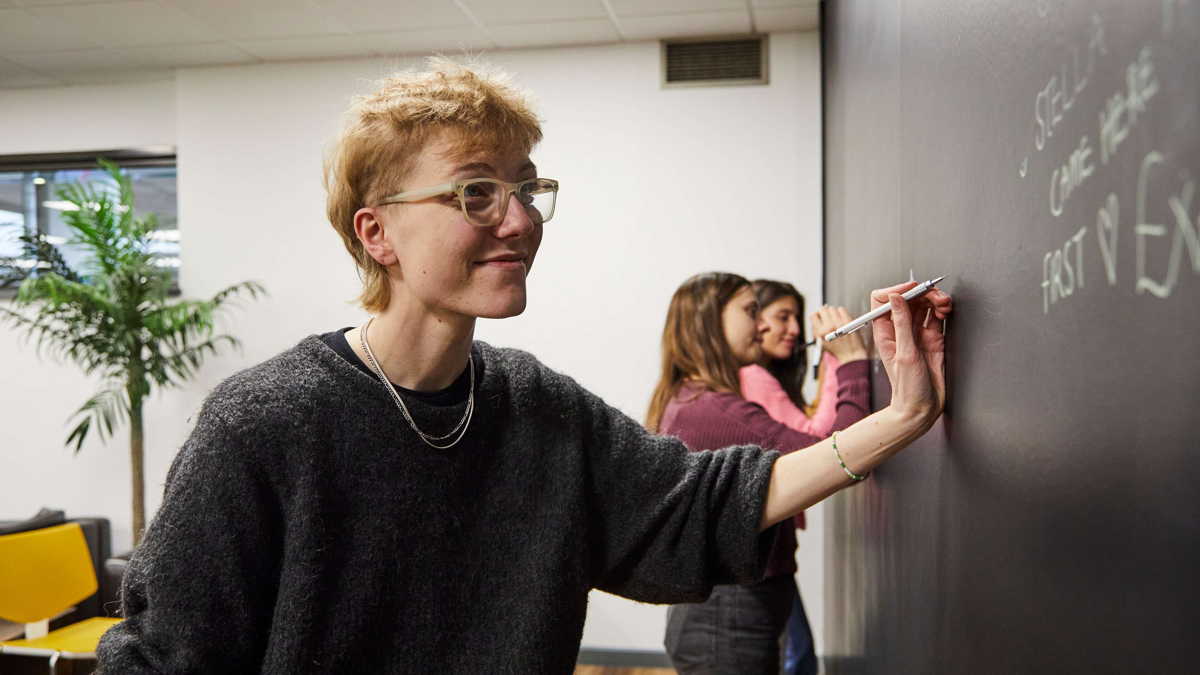 Students writing on an interactive wall at the Warren