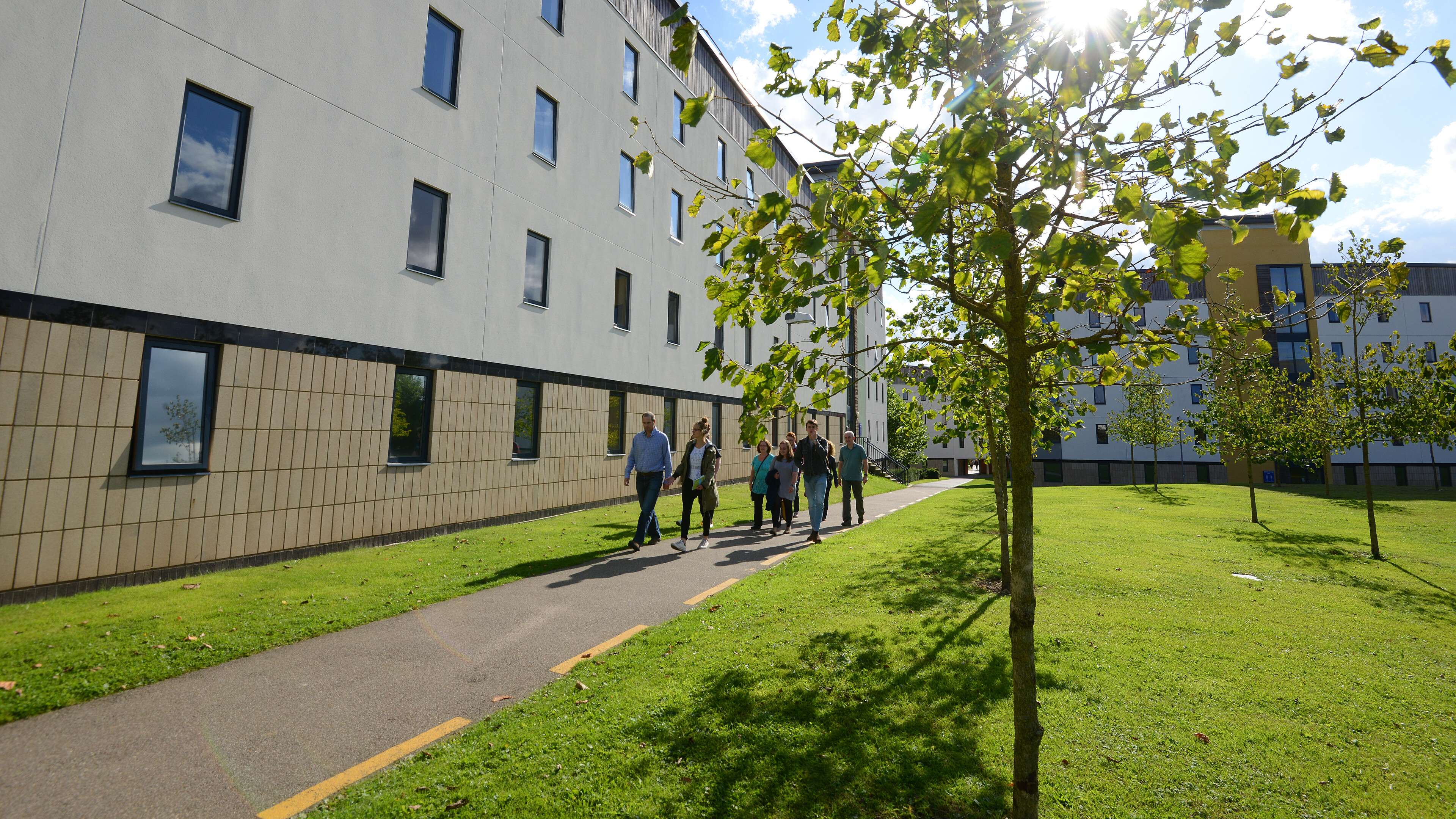 visitors walking through campus on a sunny day
