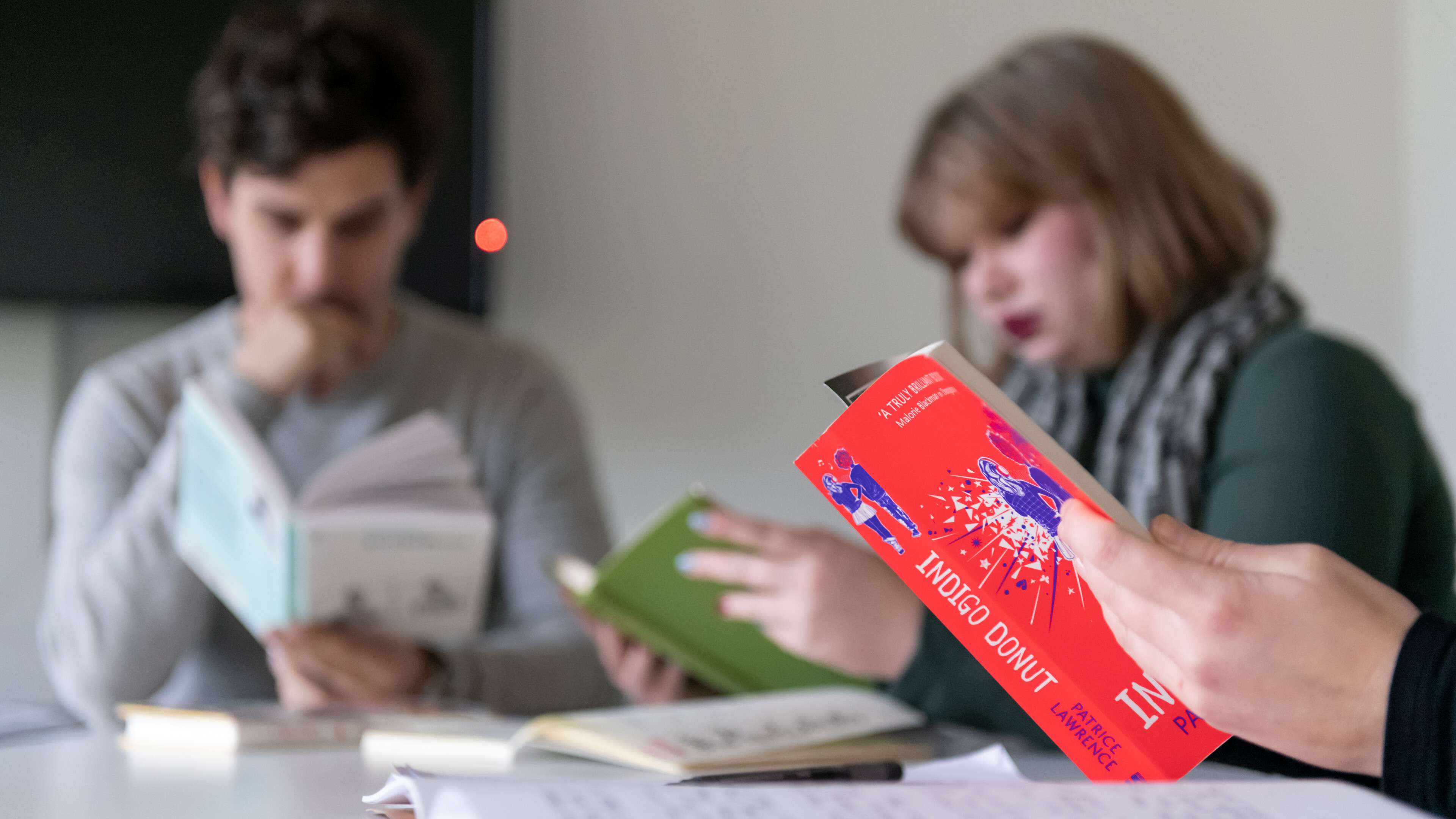 Group of students sat around a table reading books