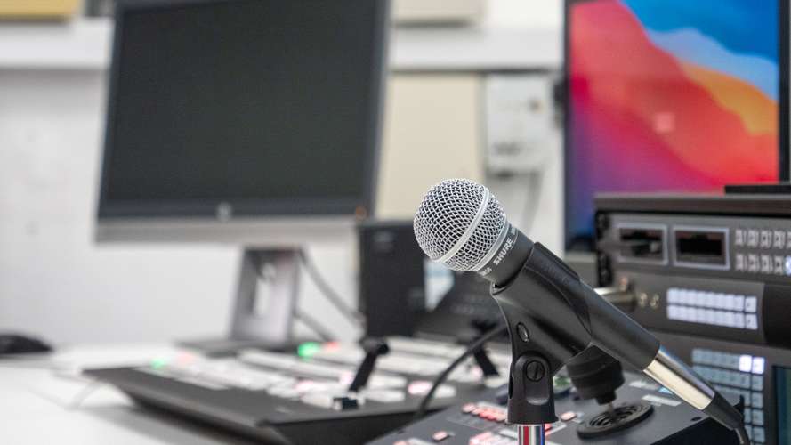 Microphone, minor and desk in the control room of UEA's Broadcast house.