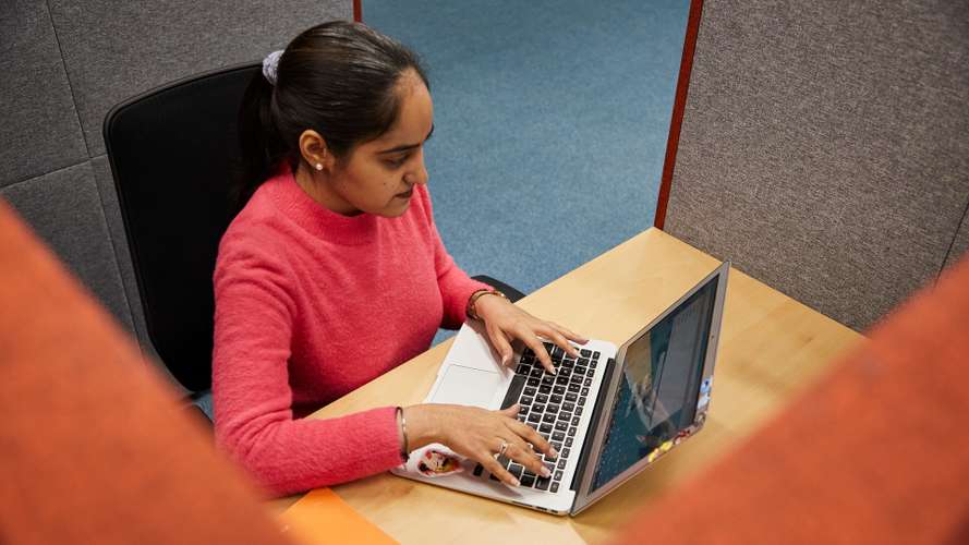 Student using a bookable study pod in the Library