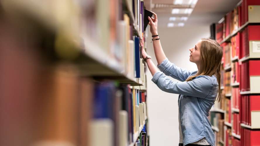 Student searching for books in the Library