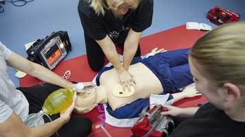 Paramedic science students practicing on a dummy with equipment