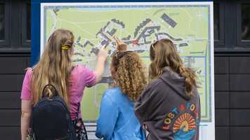 Visitors and a student ambassador consult the campus map