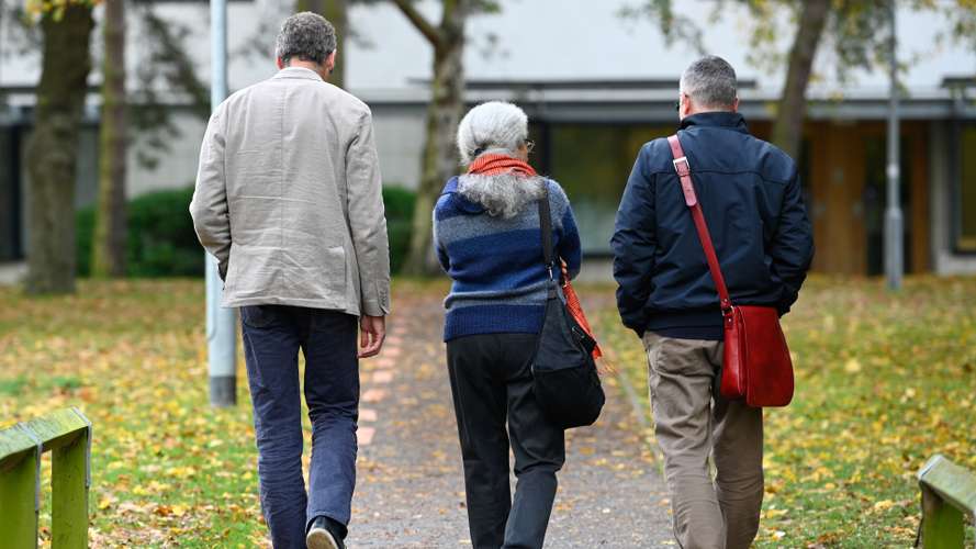 UEA staff members walking and talking on campus together.