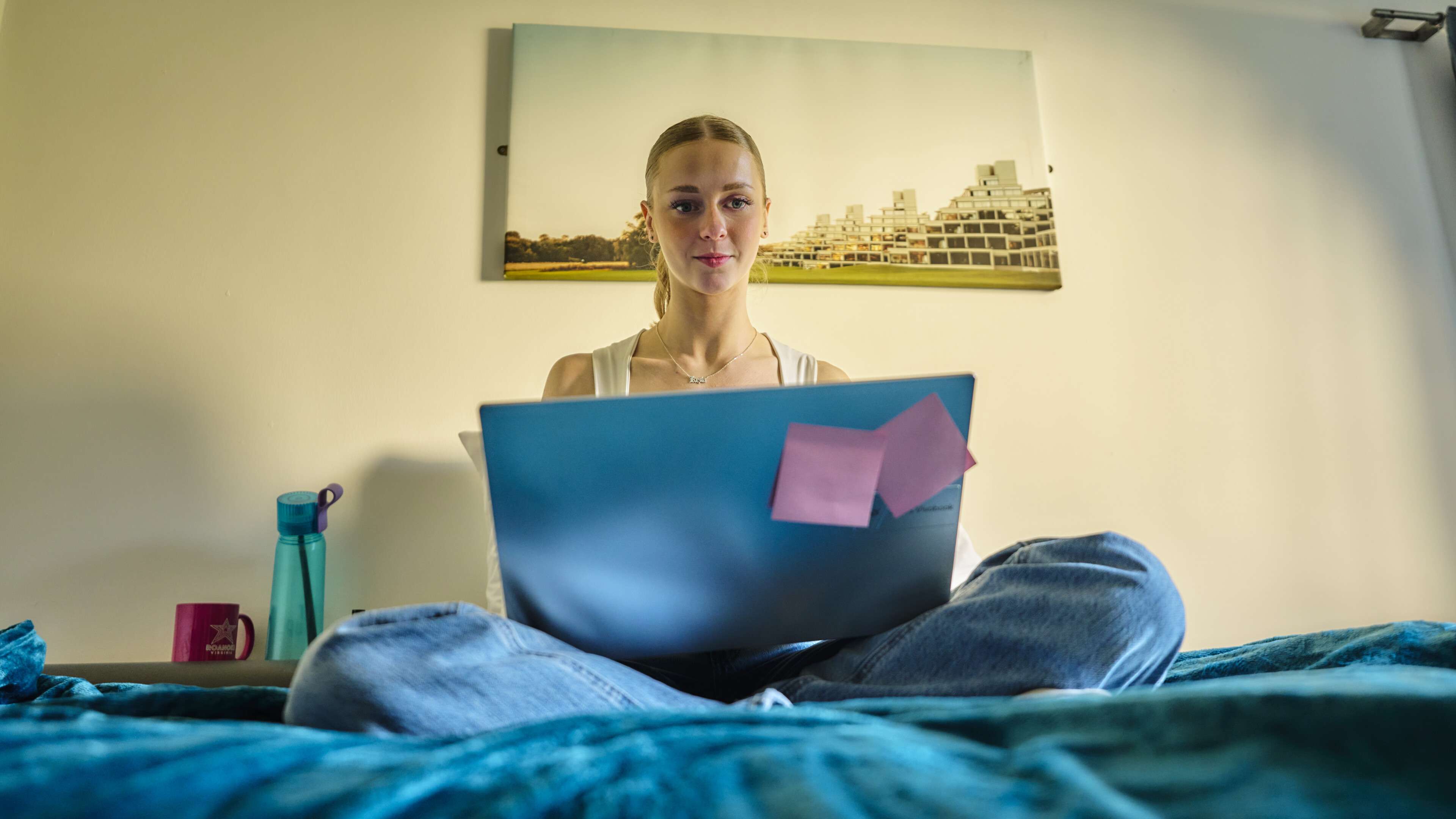 Student in campus bedroom with laptop