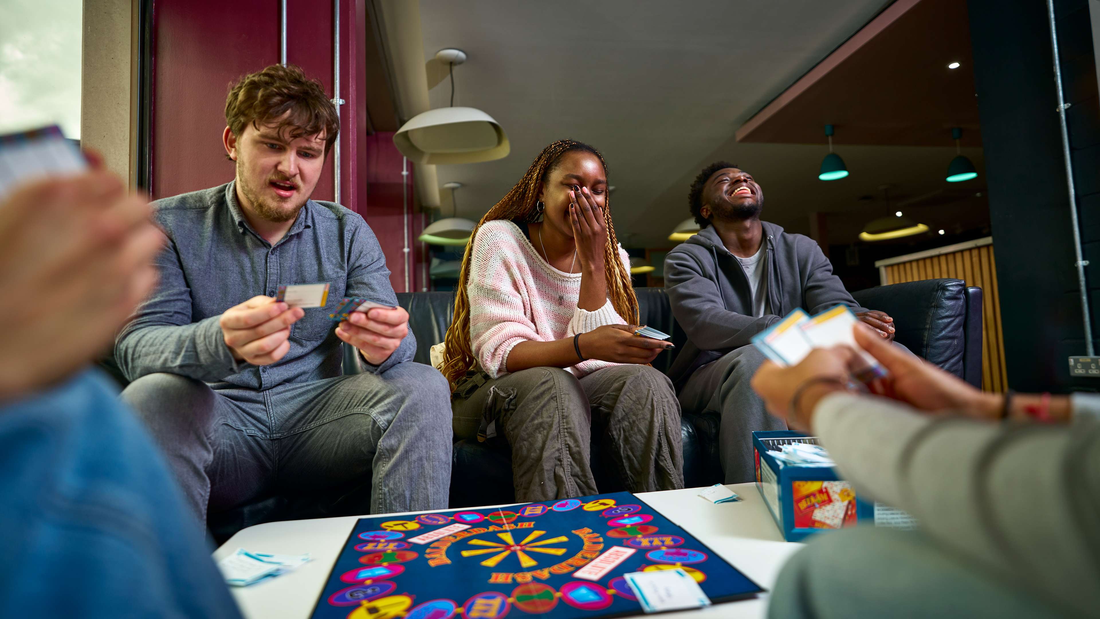A group of students play a boardgame.