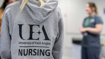 UEA Nursing hoodie from the back, with out of focus lecturer to one side