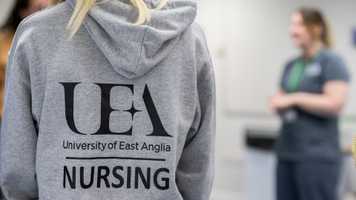 UEA Nursing hoodie from the back, with out of focus lecturer to one side