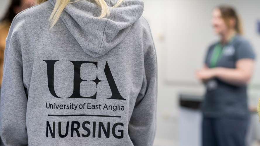 UEA Nursing hoodie from the back, with out of focus lecturer to one side