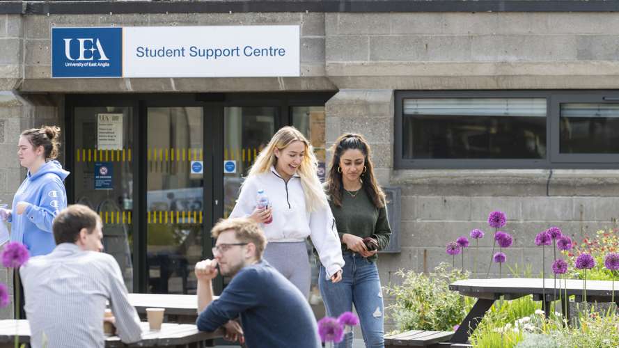 Students walking and talking in front of Student Support Centre on campus