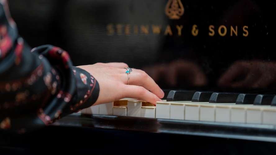 A student playing piano in the Strode Room in the Music Centre at UEA.