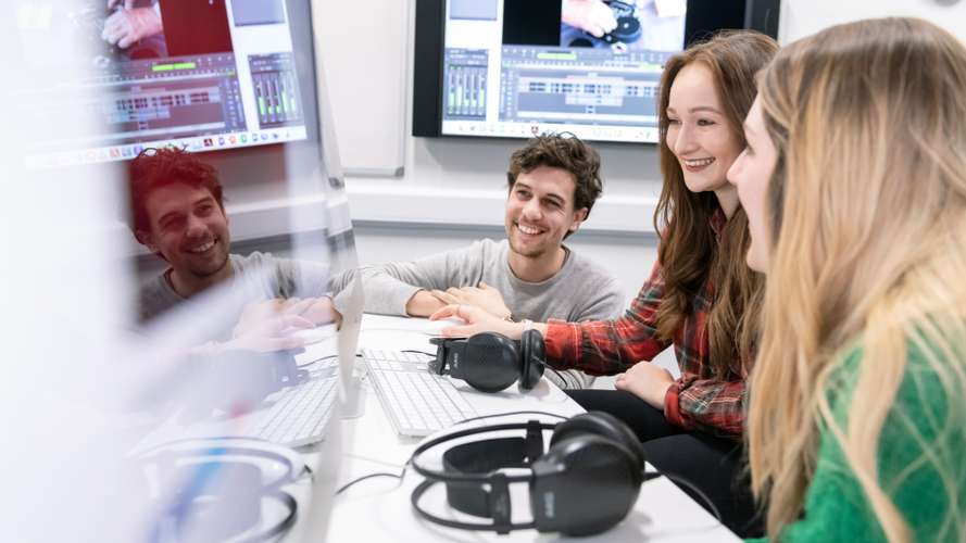 Students sat around a computer screen