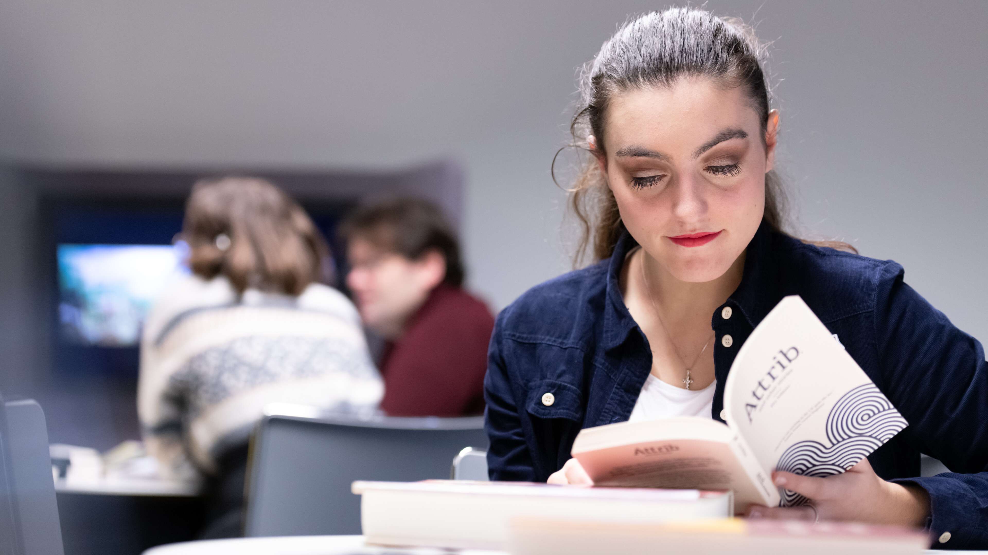 Student sat at a table reading a book