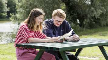 Two students studying by the UEA Broad