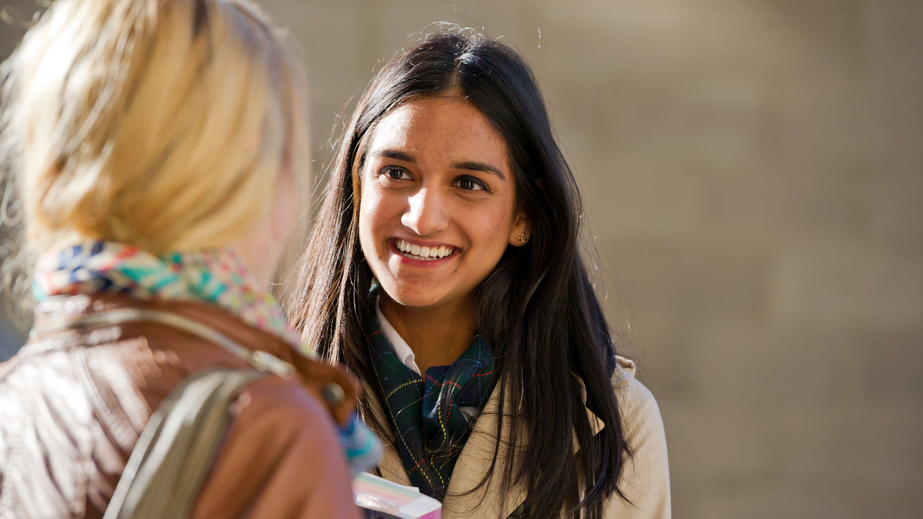 2 young women talking to each other.