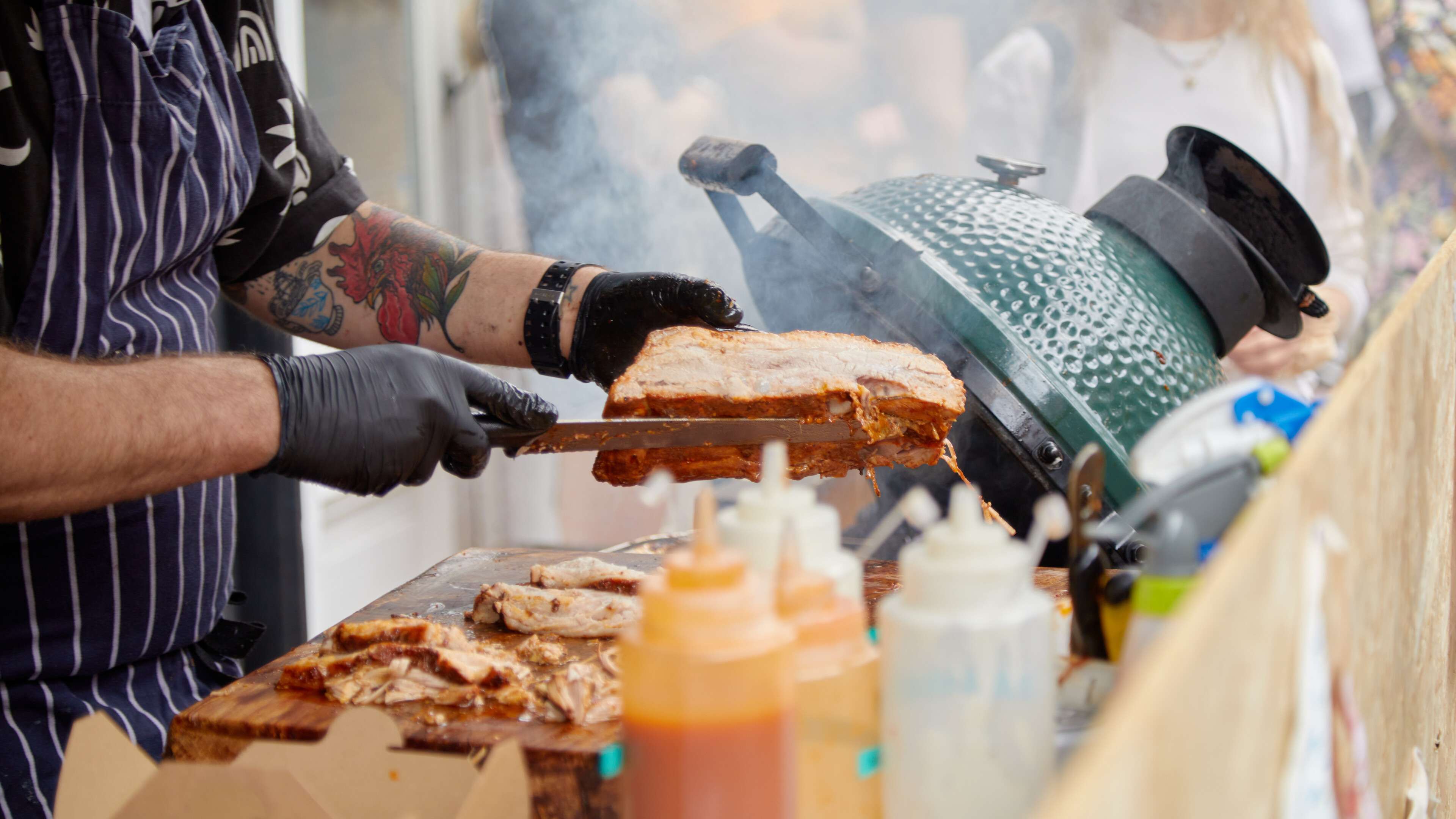 Man carving steaming meat at a food stall in Norwich