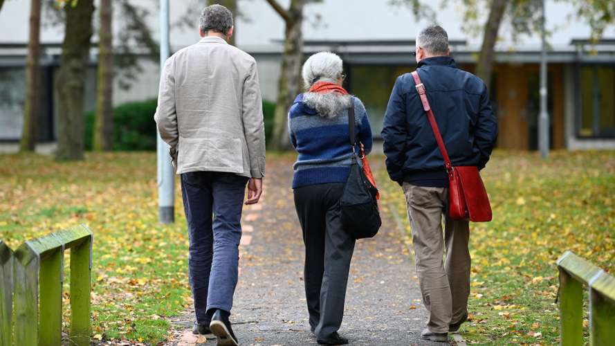 UEA staff members walking and talking on campus together.